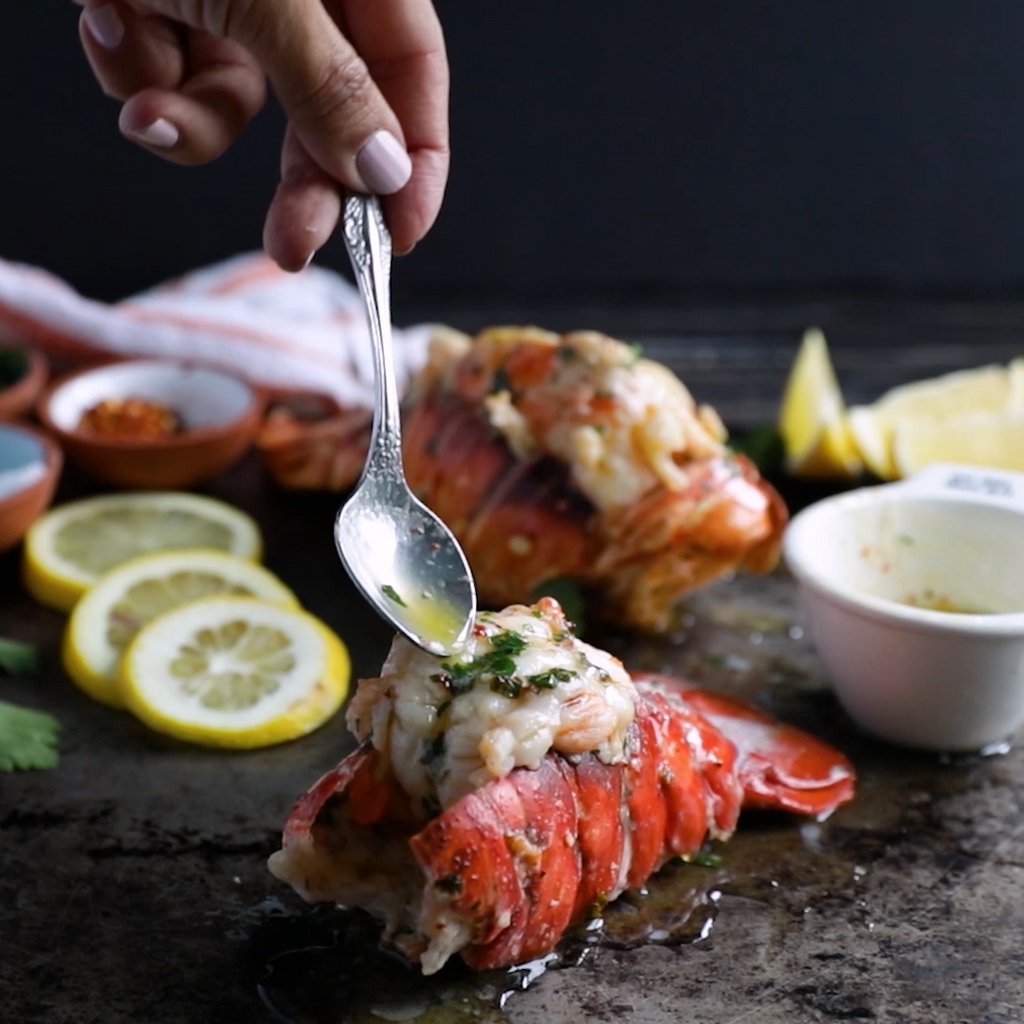 Butter sauce being drizzled over a cooked lobster tail