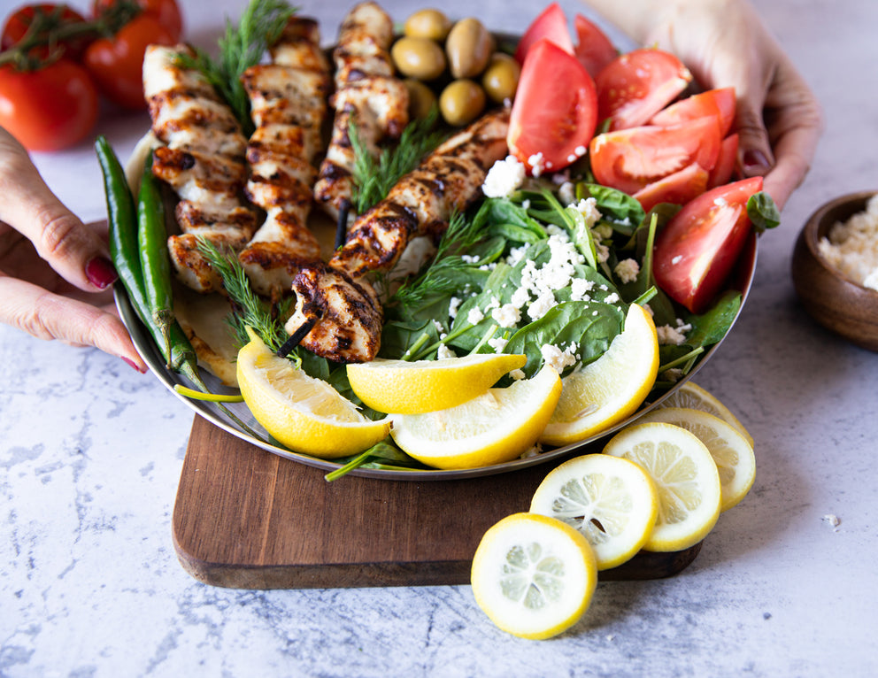 Sealand Chicken Souvlaki Skewers Plated with Tomatoes and Fresh Greens