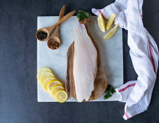 Sealand Quality Foods Raw Red Group Fillet on a Board with Lemon