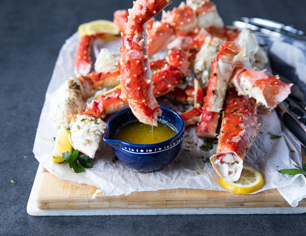 Whole colossal king crab legs dipped in melted butter