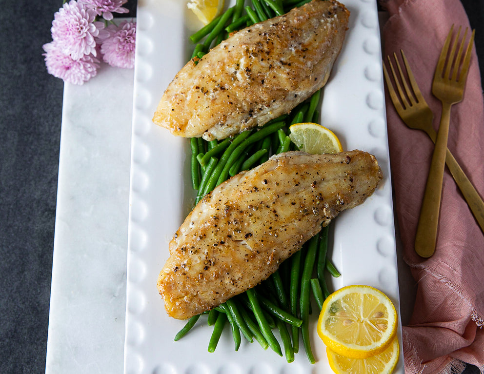 Two Sealand Red Snapper Fillets Cooked and Plated on Top of Green Beans