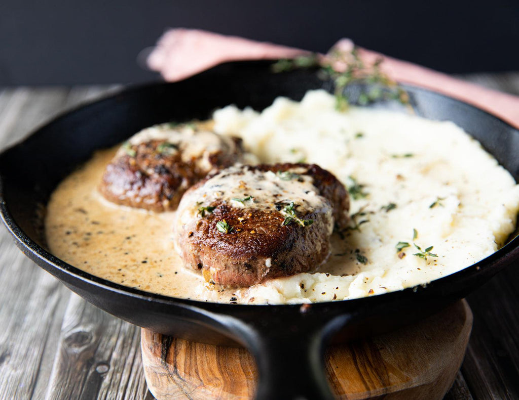 Sealand's 6oz Filet Mignon Steaks in a cast iron skillet with mashed potatoes and rosemary.