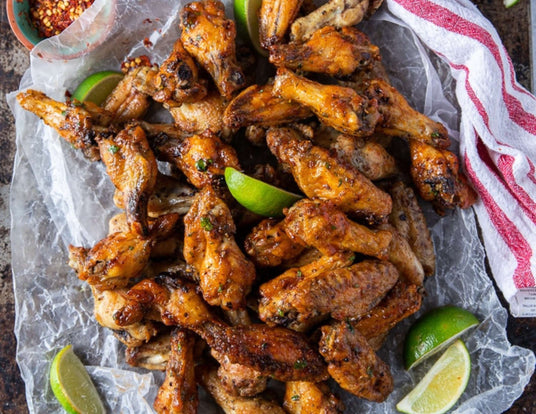 Platter of Air Fryer Chicken Wings Sauced and Served with Limes