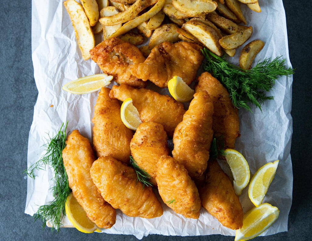 Battered Haddock Fillets with potato wedges and fresh dill.