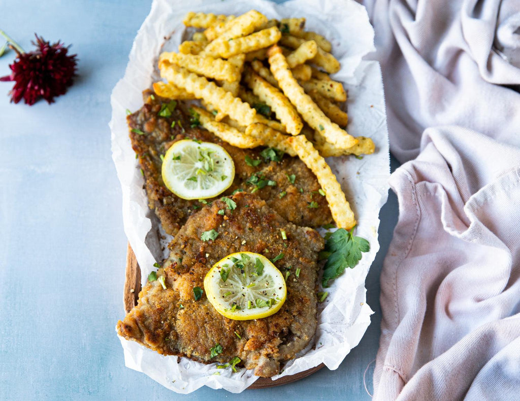 Sealand Quality Foods' Breaded Veal Schnitzels served with fries and a slice of lemon.