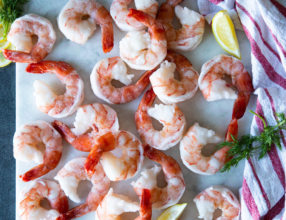 Frozen Extra Large Cooked Black Tiger Shrimp Spread Out on a Cutting Board