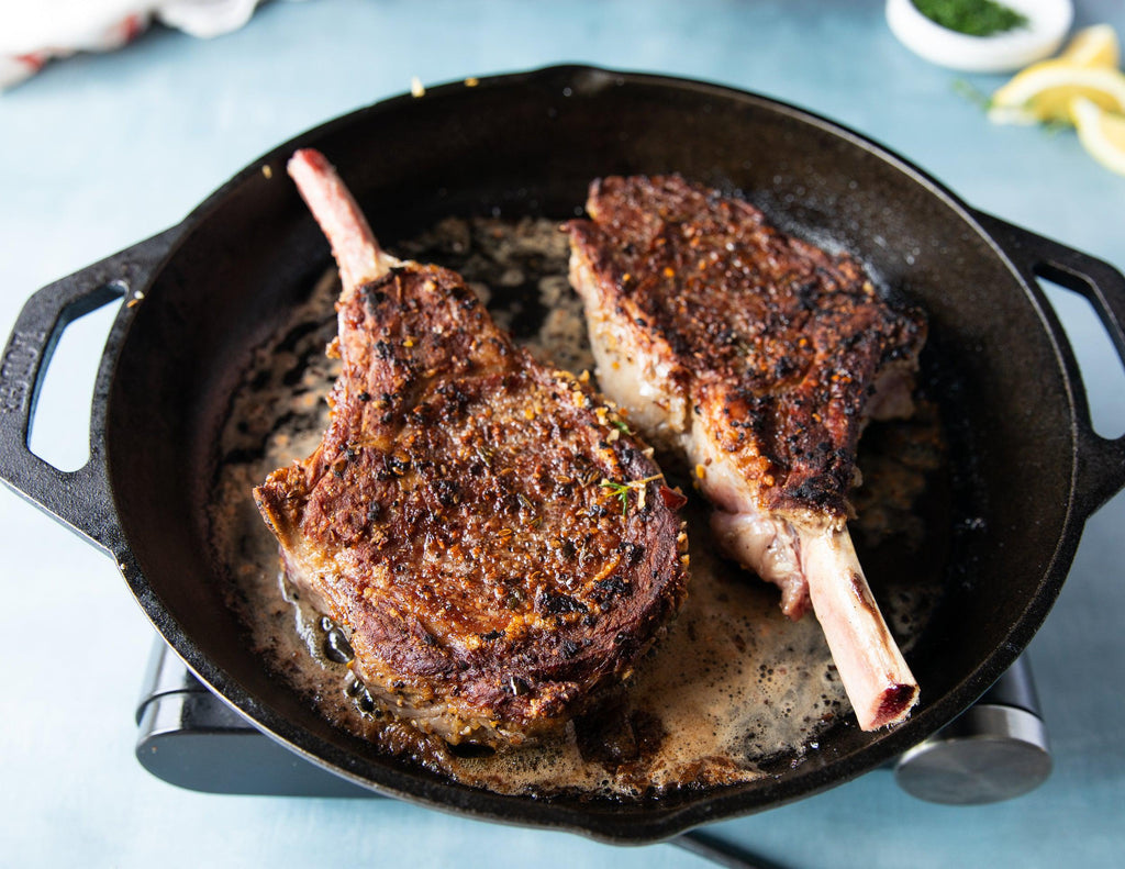 French Cut Grain Fed Veal Chops seared in a cast iron skillet.