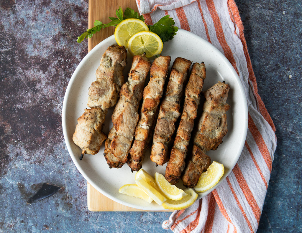 Sealand Quality Foods Fully Cooked Pork Souvlaki Skewers Plated with Lemon