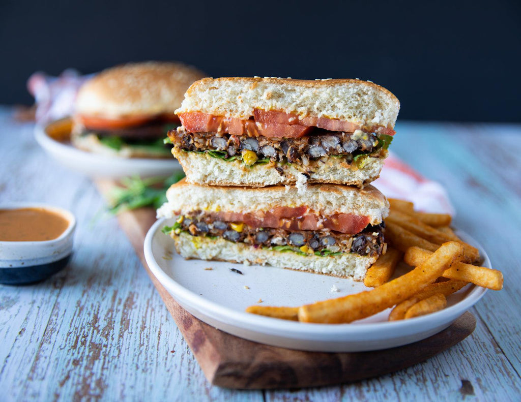 Sealand Quality Foods Gluten-Free Chipotle Black Bean Burgers Stacked on a Plate with Fries