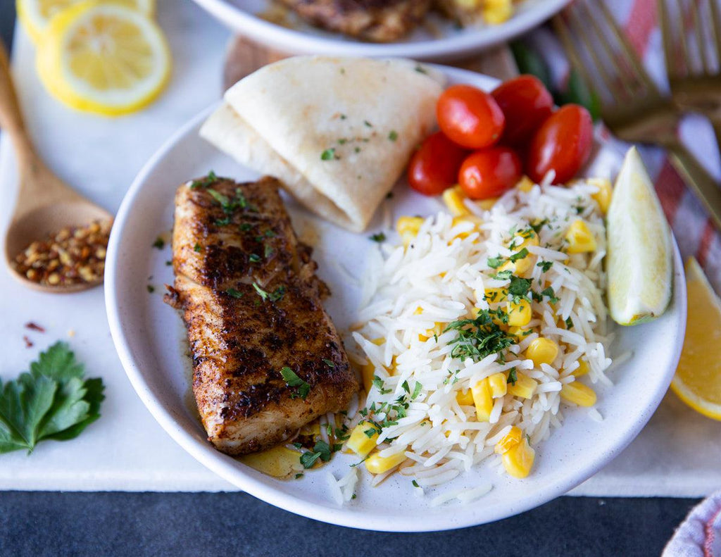Sealand's Haddock Loins plated with a  rice and corn medley, tomatoes and pita bread.