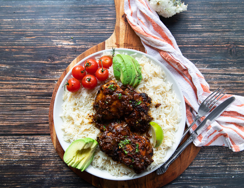 Mexican Chicken Thighs Plated with Rice, Avocado and Tomatoes