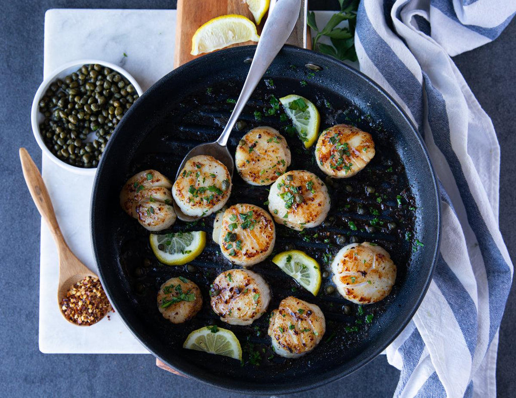 Sealand Quality Foods' Natural Dry Scallops seared on a cast iron skillet.
