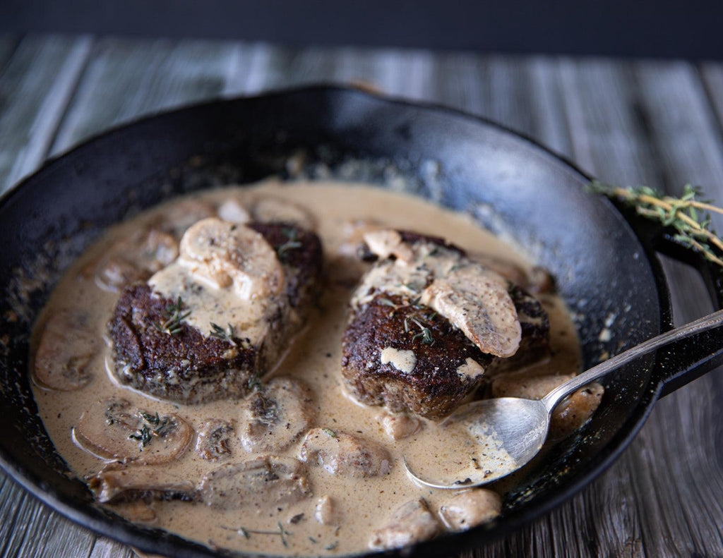 Sealand's Wagyu Tenderloin Steaks seared in a cast iron skillet with a creamy mushroom gravy sauce.