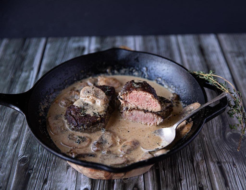 Sealand's Wagyu Tenderloin Steaks seared in a cast iron skillet with a creamy mushroom gravy sauce.